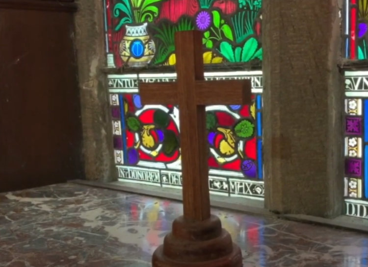 Simple cross and stained glass at St Maughans